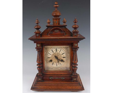 A late 19th century German walnut cased mantel clock by Junghans, with eight day movement striking on a gong, the case with t