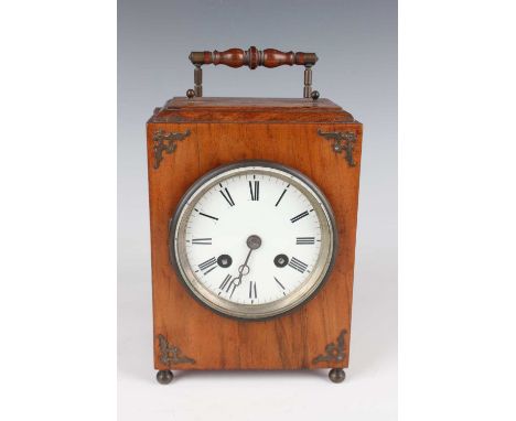 An early 20th century walnut cased mantel clock with eight day movement striking on a bell, the circular enamelled dial with 