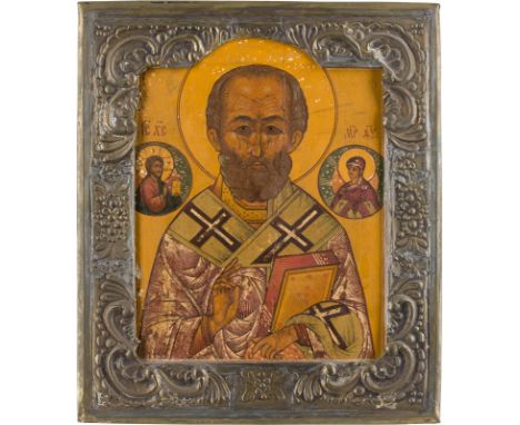 AN ICON SHOWING ST. NICHOLAS OF MYRA WITH BASMA Russian, 19th century Tempera on wood panel. Overlaid with a brass basma. Lef