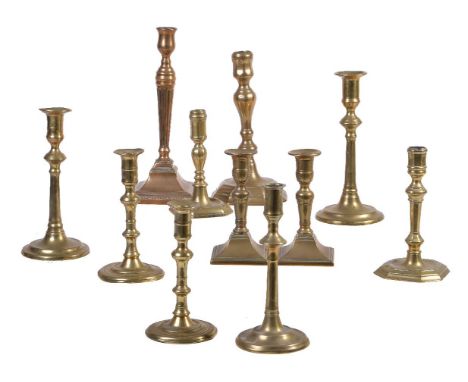 A pair of George III brass candlesticks, mid 18th century, the urn sockets above ring moulded spreading stems each cast with 