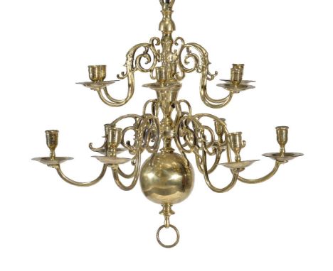 A Dutch or English brass twelve light chandelier, early 18th century, the sconces arranged in two tiers of scrolling branches