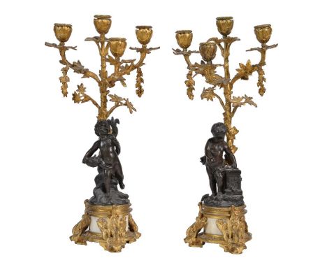 A pair of gilt and patinated metal and white marble mounted four light figural candelabra in Louis XV/XVI transitional style,