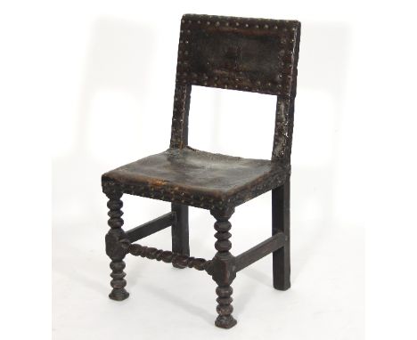 An oak chair of 17th Century design, with brass studded leather seat and back on bobbin turned legs and front stretchers/Prov