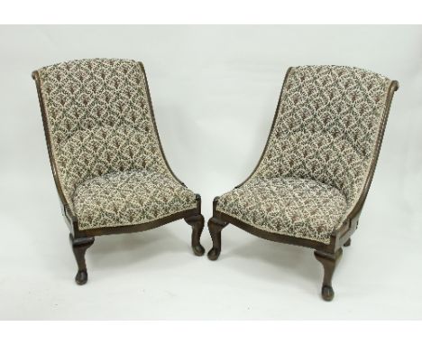 A pair of nursing chairs, each with scroll beech frames with gilt metal flowerhead terminations, deep button back and upholst