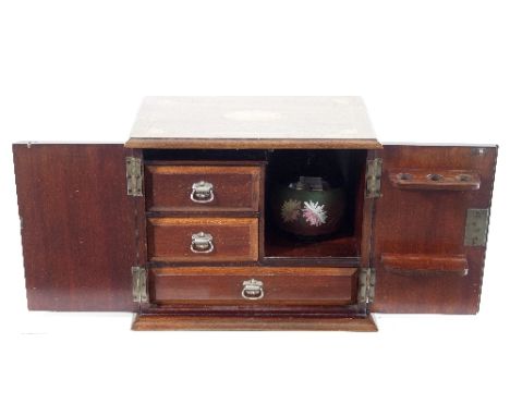 An Edwardian smoker's cabinet, the hinged cover and twin panel doors inlaid batswing patera and enclosing a pipe rack, tobacc