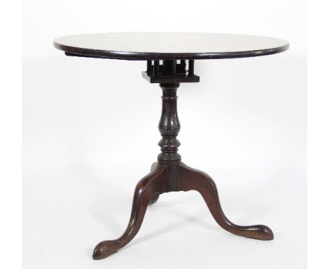 A George III mahogany table on a revolving birdcage action turned column and tripod support, 84cm diameter