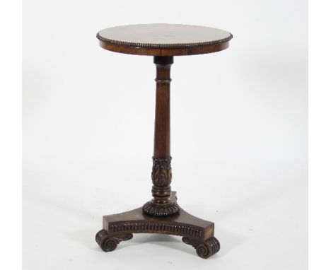 A Regency mahogany tripod table, the circular top with gadrooned border, on an acanthus leaf carved column and gadrooned trif