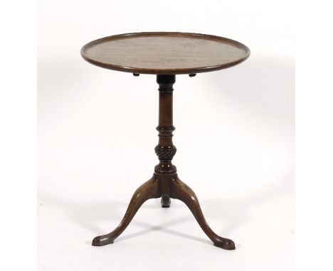 A circular mahogany tripod table, on a turned and carved column, the dished tip-up top 61cm diameter