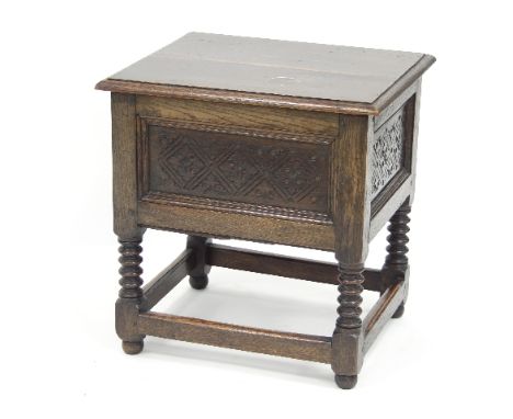 An oak box top chest with hinged cover and carved panels to the front and sides, on bobbin turned legs united by square stret