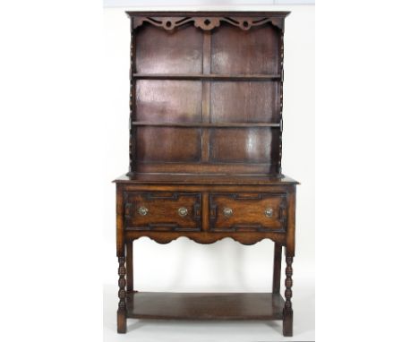 An oak dresser with shelves over, the base with two drawers and pot board beneath on bobbin-turned legs, 107cm wide