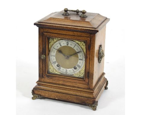 An Edwardian mantel clock in a rosewood case with lion masks to the sides and handle to the top, with brass dial and silvered