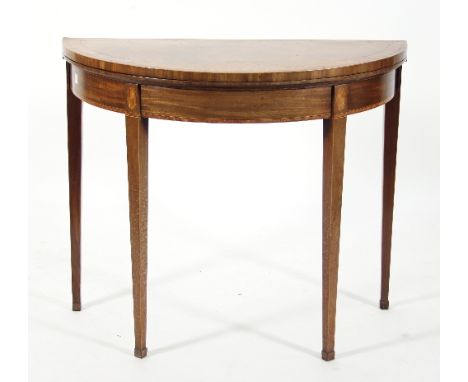 A Regency walnut demi-lune card table with crossbanded folding top and inset baize, on tapered legs inlaid with ovals, 84cm w