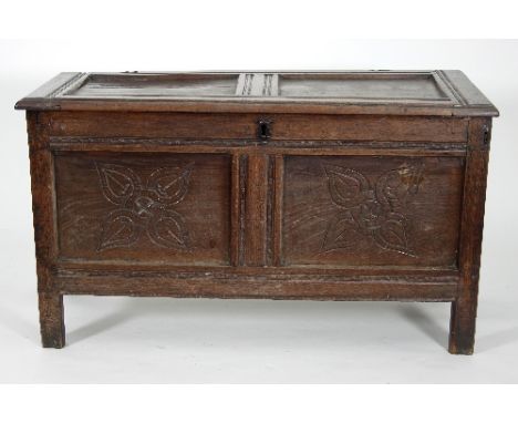 An 18th Century and later oak coffer with hinged panel top and stylised floral carving to the front, 110cm wide