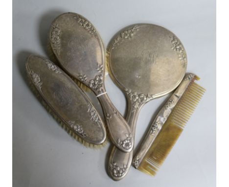 A four piece silver mounted mirror and brush set.