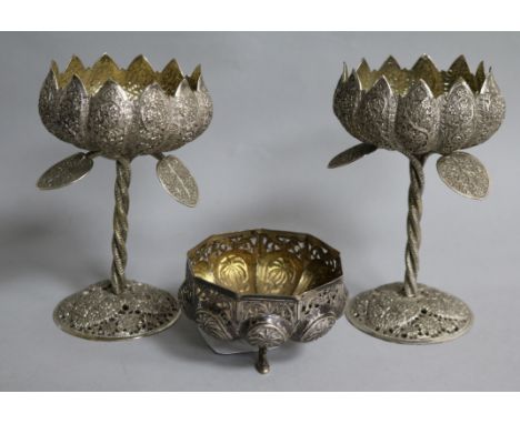 An Indian white metal footed bowl and a pair of white metal lotus shaped decorated cups.