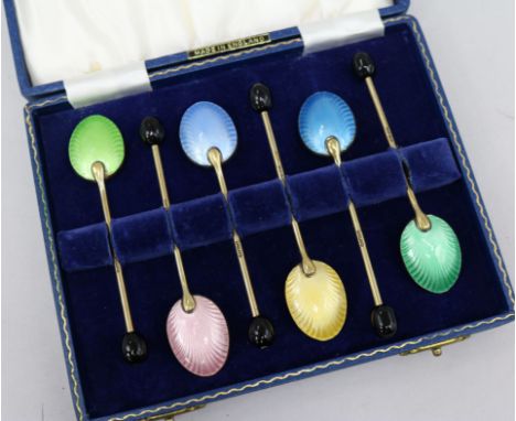 A cased set of enamel spoons