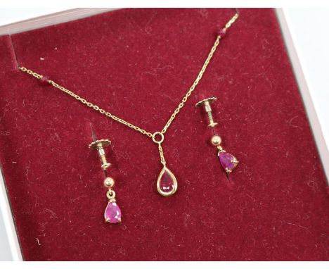 A ruby and 9ct gold pendant and a pair of earrings en suite, the pendant on 9ct gold fine chain with ruby spacers