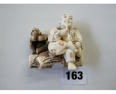 Early 20thC Ivory Netsuke of a Wise man smoking opium on a log with Wise man, character mark to base, 6cm in height 