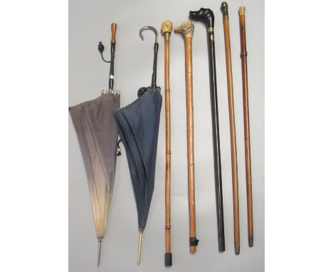 Collection of vintage walking sticks, two with dog terminals, one with a mask head, etc. Together with vintage parasols.(B.P.