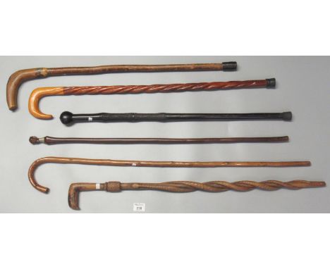 Collection of vintage walking stick/canes, one with entwined snake shaft and another with African style mask head handle.(B.P