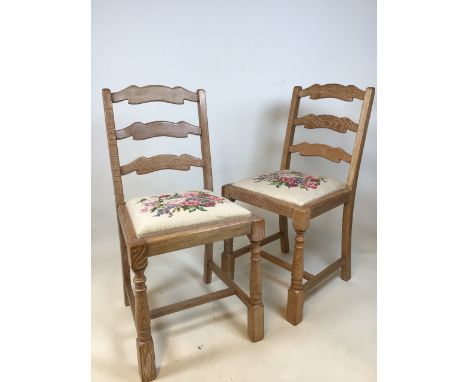 A pair of carved ladder back limed oak chairs with tapestry seats. Stamped F172 to frame. Possibly form Heals 