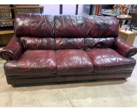 A good quality Oxblood red leather three seater sofa with stud details. W:222cm x D:110cm x H:98cm