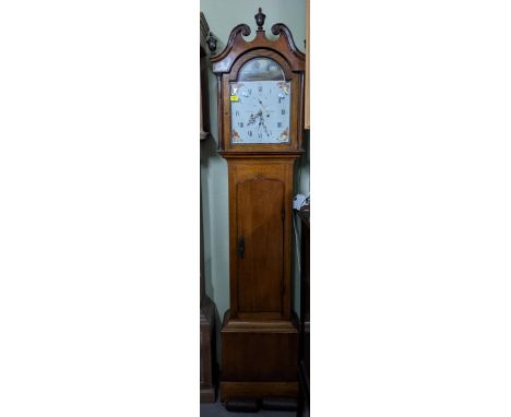 A Georgian oak and mahogany cased longcase clock, the painted arched face with a Country Estate ploughing scene, four floral 