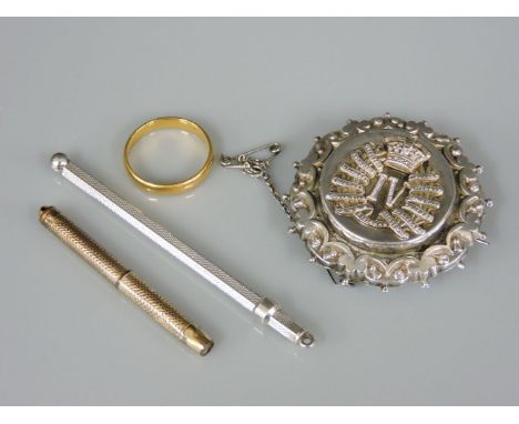A 22ct gold wedding ring, 3.95g, a silver military brooch, a swizzle stick, and a yellow metal pencil