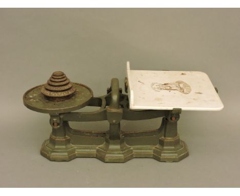 A set of cast iron and ceramic counter top shop scales, with circular weights