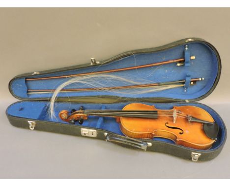A German three quarter size violin, circa 1890, with two piece back, and two bows, one stamped 'Bausch', in case, bears paper