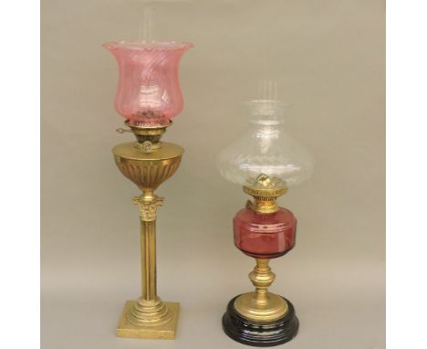 A Victorian Corinthian column brass oil lamp, with a frilled ruby glass shade, 77cm high, and an Edwardian brass oil lamp, wi