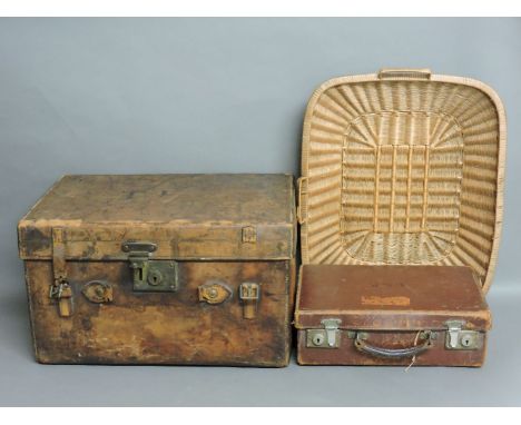 A leather trunk, a smaller suitcase, two wooden dairy bowls, earthenware crockery, and a wicker bread basket