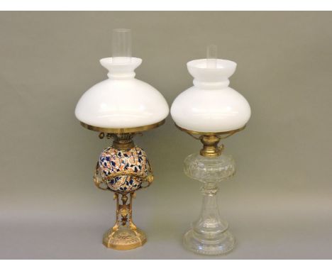 A late Victorian oil lamp, with a ceramic double burner, painted in the Imari palette and supported by an ornate gilt metal b