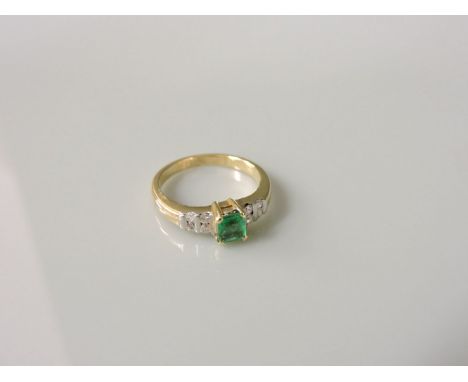 A single stone emerald ring, with pairs of barette set diamonds to each shoulder, marked indistinctly 14k 585