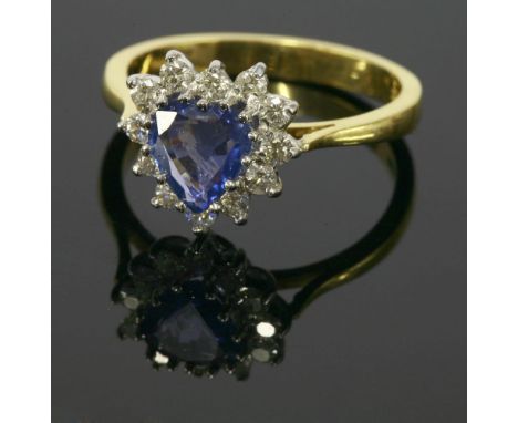 An 18ct yellow and white gold sapphire and diamond cluster ring, a heart shaped sapphire claw set to the centre, surrounded b