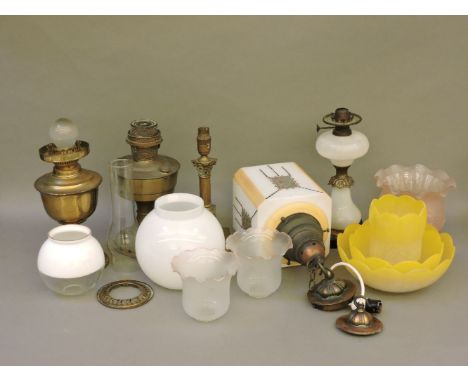A Victorian glass and gilt metal oil lamp, Victorian glass light shades, brass lamps, and two Art Deco glass light shades