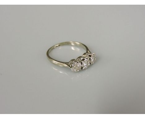 A three stone diamond illusion set ring, marked 18ct plat