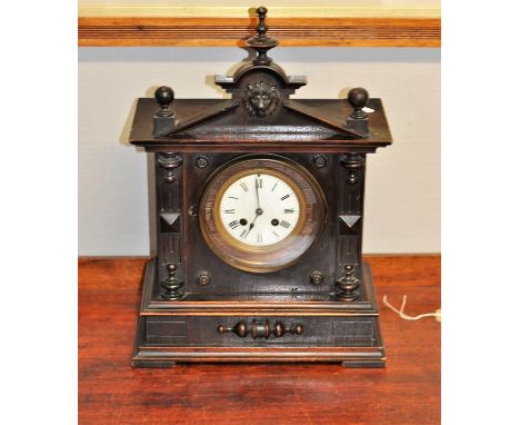 Late 19th century mantle clock in oak temple-shaped case with key and pendulum 45cm tall 