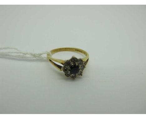 An 18ct Gold Cluster Ring, of flower head design, claw set centre, within illusion set border, between bifurcated shoulders, 