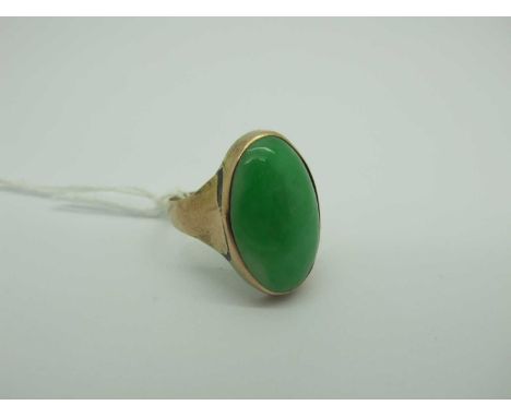 A Chinese Jade Coloured Ring, oval cabochon set, between wide tapered shoulders, stamped "14K" (finger size S) (5 grams)The r