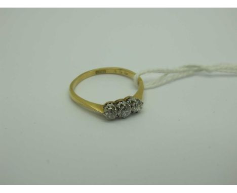 A Three Stone Diamond Ring, the old brilliant cut stones claw set, stamped "18ct" (finger size Q).The ring weighs 2.5 grams