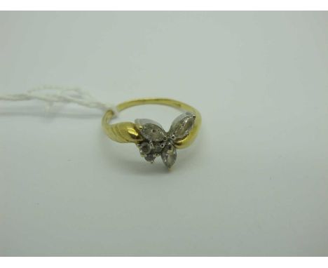 A Modern Dress Ring, claw set mixed cut stones between crossover style shoulders, stamped "750" (finger size R½) (3.5 grams).