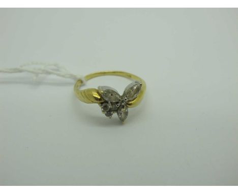 A Modern Dress Ring, claw set mixed cut stones between crossover style shoulders, stamped "750" (finger size R½) (3.5 grams).