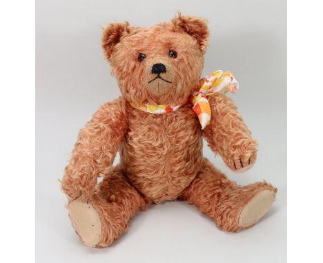 A Schuco apricot mohair Teddy bear, 1930s, with glass eyes, clipped muzzle with black stitched nose, mouth and claws, swivel 