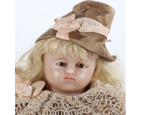 A good poured wax shoulder head doll in original clothing, 1870s, with brown glass eyes, delicately painted mouth and brows, 