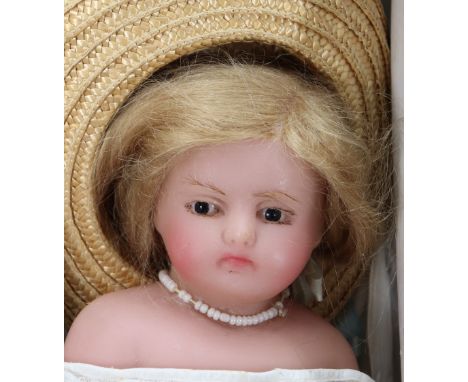 A poured wax shoulder head doll, probably Pierotti, English 1860, the slightly turned head with fixed brown glass eyes, mould