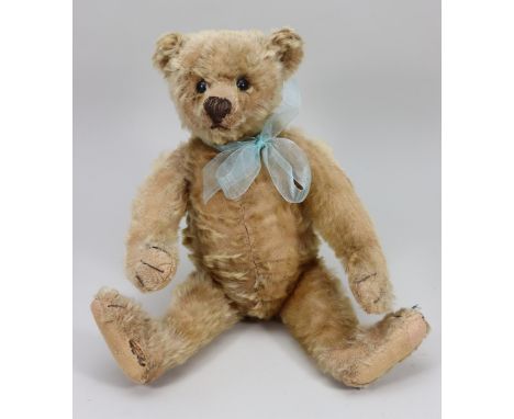 A Steiff golden mohair Teddy bear, circa 1909, the straw filled bear with boot button eyes, horizontally brown stitched nose 