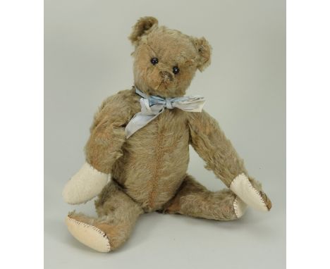 A Steiff blonde mohair Teddy bear, circa 1909, the straw filled bear with boot button eyes, horizontally brown stitched nose 