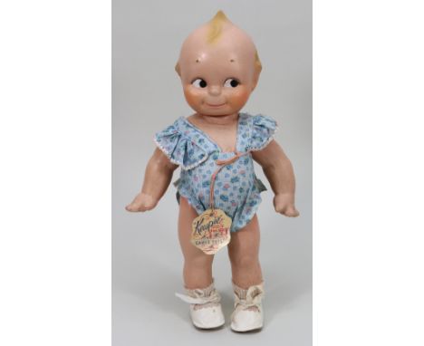 A Rose O’Neill Cameo composition Kewpie doll, 1930s, with painted side glancing eyes, water melon smile and moulded top-knot,