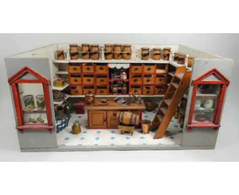 A good child’s shop room set, German 1890s, the painted grey wooden exterior with two glazed windows and red moulded frames, 